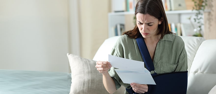 injured woman upset looking at insurance paperwork