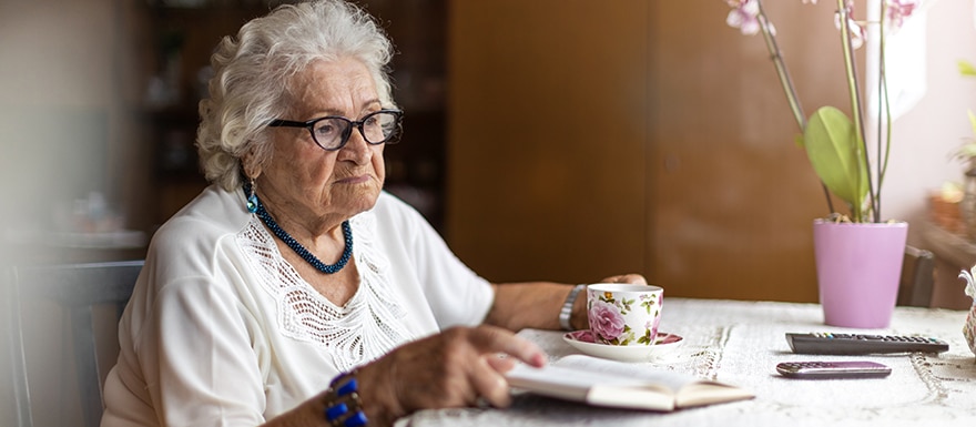 Elderly woman sitting alone at table