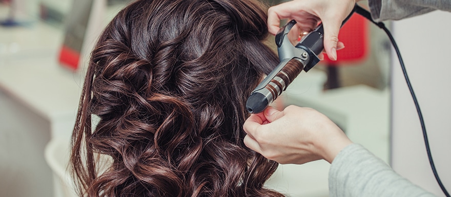 Using a hot curling iron on hair