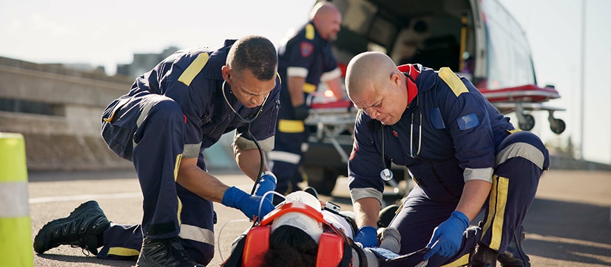 Emergency medical team attending to injured person from accident on highway