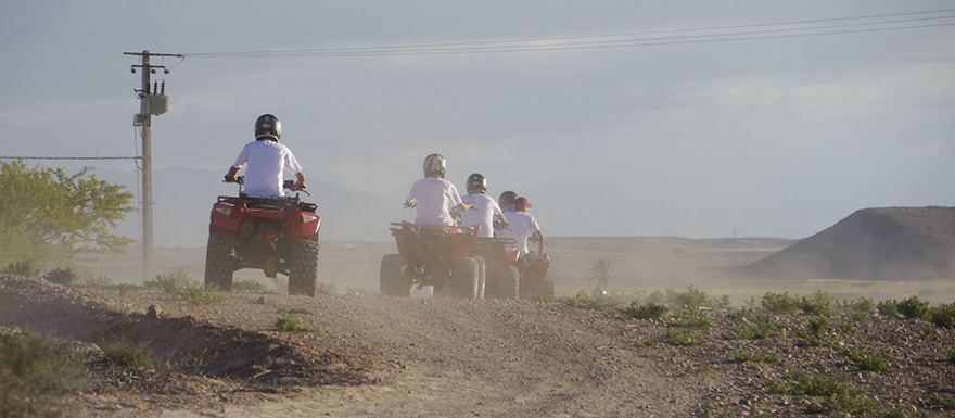 Multiple ATVs being driven on dirt and gavel path