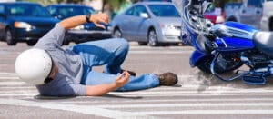 Man fallen off motorcycle on busy road